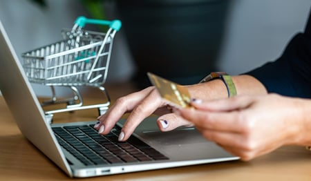 Woman typing credit card number into online store.